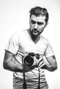 Harismatic guy takes photo in studio. Professional photographer. Hobby. Black and white photo Royalty Free Stock Photo