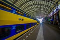 Harlem, Amsterdam, Netherlands - July 14, 2015: Inside railroad station, large roof covering platform, blue and yellow Royalty Free Stock Photo