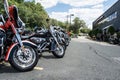 Harley Davidson motorcycles parked on the street and motorcyclists chatting in the background