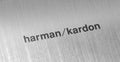 Harman Kardon logo on the polished metal background. Harman / Kardon is an American company