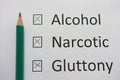 Harmful habits: alcohol, drugs, gluttony are written on white paper in pencil. Get rid of bad habits.