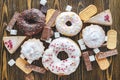 Harmful sweet foods on a dark wooden background. Donuts and muffins on the table pile. Unhealthy diet and overweight