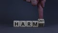 From harmful to harmony. Businessman turns the wooden cube and changes word harmful to harmony. Beautiful grey table, grey
