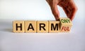 From harmful to harmony. Male hand turns the cube and changes the word `harmful` to `harmony`. Beautiful white background.