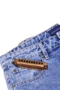 Harmonica, musical instrument, lies on denim pants.