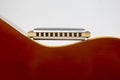 The harmonica rests on the top of the classical guitar. Classical musical wind instrument Royalty Free Stock Photo