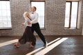 Harmonious senior dance couple dancing tango at the ballroom