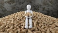 Harmony Amidst Pellets: White Stick Figure Rests on Timber Stack