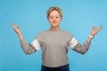 Harmony and balance. Tranquil woman with short curly hair in sweatshirt holding fingers in mudra gesture and meditating