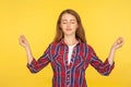 Harmony and inner peace. Portrait of happy calm ginger girl in checkered shirt practicing yoga, holding hands in namaste gesture Royalty Free Stock Photo