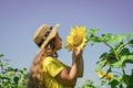 In harmony with nature. kid wear straw summer hat. child in field of yellow flowers. teen girl in sunflower field Royalty Free Stock Photo