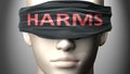 Harms can make things harder to see or makes us blind to the reality - pictured as word Harms on a blindfold to symbolize denial