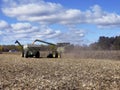 John Deere combine harvesting corn and unloading into Killbros 1950 grain wagon