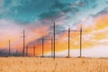 Harvest Field Under Power Line Background. Harvest Field Combination Nature And Technologie. Bright Colors. Fiery Sunset