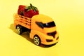 Harvest of fresh juicy strawberries is transported by a children`s toy truck.