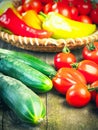 Harvest of fresh ripe vegetables on wooden table and in rod bowl - pepper, tomato, cucumber. Royalty Free Stock Photo