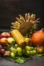 Harvest fruits and vegetables with a sunflower on a dark wooden table, on the wooden background, close up Royalty Free Stock Photo