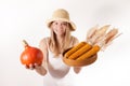 Harvest girl with hat is offering pumpkin and corn