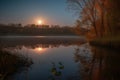 harvest moon reflections on the calm surface of a lake Royalty Free Stock Photo