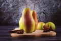 Harvest pears on a board in the shape of a pear. Autumn composition of fruits with cinnamon and anise.