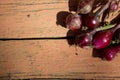 Harvest of red onions lies on a painted wooden surface