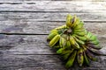 A harvest of saba banana (also known as cardava banana or kepok banana) on wooden background.