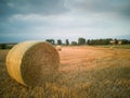 Harvest straw bale farmhouse stormy clouds view