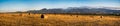 Harvested Field with Hay Bales Under Mountains Royalty Free Stock Photo