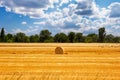 Harvested wheat field with rolled haystack. at the end of summer, harvesting under the picturesque sky