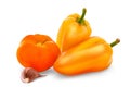 Harvested Yellow Colored bell peppers and orange tomato and garlic over white background Royalty Free Stock Photo