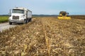 Harvester combine and semitruck in corn field during harvest Royalty Free Stock Photo