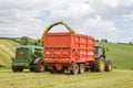 Harvester forager cutting field, loading Silage into a Tractor Trailer Royalty Free Stock Photo