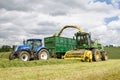 Harvester forager cutting field, loading Silage into a Tractor Trailer Royalty Free Stock Photo