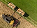 Drone view of harvester loading off corn on trailers