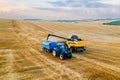 Harvester machine skillfully depositing wheat grains into a tractor trailer Royalty Free Stock Photo