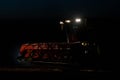 Harvester at work on field at night Royalty Free Stock Photo