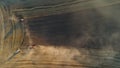 The harvesters harvest grain in a wheat field. Wonderful summer rural landscape, view from the drone.