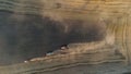 The harvesters harvest grain in a wheat field. Wonderful summer rural landscape, view from the drone.