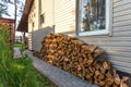Harvesting firewood for the winter near wooden village vacation home. modern eco country house in a pine forest at sunset