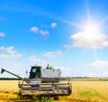 Harvesting machine working at field in sunny morning Royalty Free Stock Photo