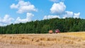 Harvesting wheat on a summer day. A ÃÂombine harvester is working on harvesting cereals in a field on a sunny day. A field of ripe Royalty Free Stock Photo