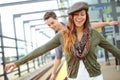 She has a child like spirirt. A smiling couple balancing along the railway of a train station with copyspace. Royalty Free Stock Photo