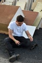 After he has done his work teenage boy sits in the bulky refuse