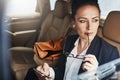 She has a great idea to share in the office. a confident young businesswoman seated in a car as a passenger while busy Royalty Free Stock Photo