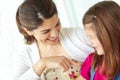 She has her mothers smile. A young mother teasing her daughter affectionately while sitting on the porch.