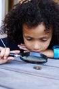 He has an inquisitive mind. a cute little boy inspecting an insect with a magnifying glass.