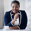 She has a lot of advice to offer. Portrait of a smiling young businesswoman sitting at a desk in an office. Royalty Free Stock Photo