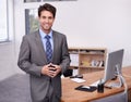 He has a lot of confidence in his company. A handsome young businessman standing in his office confidently. Royalty Free Stock Photo