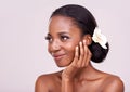 She has natural charm. An isolated studio shot of a gorgeous young woman with soft skin touching her face.