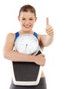 She has no problems with her weight. A pretty teenage girl carrying a scale and making a thumbs-up sign. Royalty Free Stock Photo